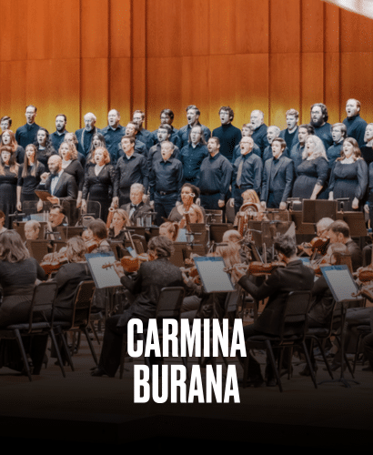 A large choir and orchestra perform on stage, all dressed in black, with the words Carmina Burana in bold white text at the bottom of the image.