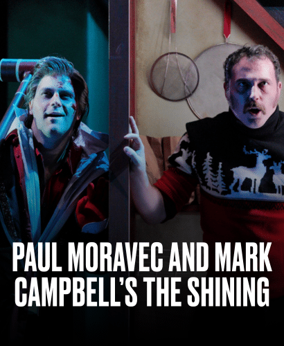 Two men stand in dramatic lighting; one wears a red jacket and holds an axe, the other wears a sweater with reindeer patterns. The text reads, Paul Moravec and Mark Campbell’s The Shining.