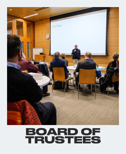 A speaker presents to a seated group in a conference room with a large screen displaying Next Steps. The scene is captioned BOARD OF TRUSTEES at the bottom.