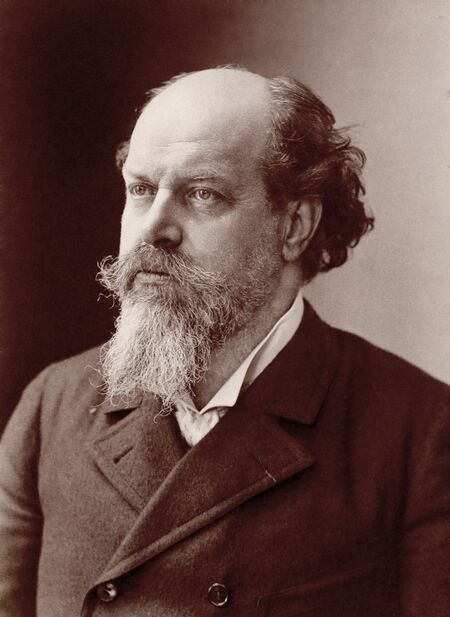 Middle-aged man, receding hairline of dark hair, moustached with white beard, looking slightly away from the camera.