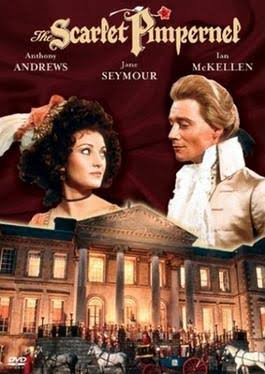 DVD cover of an adaptation of The Scarlet Pimpernel starring Anthony Andrews, Jane Seymour, and Ian McKellen. The middle section shows is a split portrait of a woman with dark hair on the left and a blond man on the right looking at each other.They are wearing 18th-century attire. The bottom section shows a brightly lit mansion at night with horse-drawn carriages and numerous people gathered on the steps.