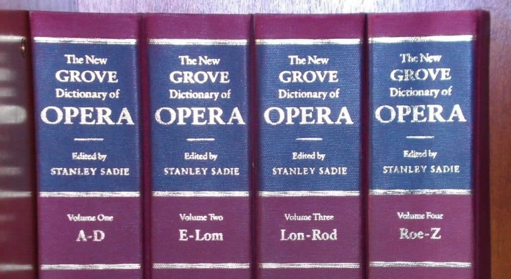 The spines of four volumes of The New Grove Dictionary of Opera in a row.